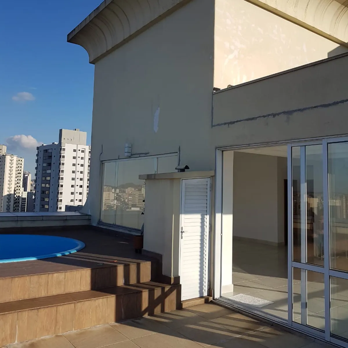 Terraço da cobertura com piscina redonda, degraus revestidos e muros sem acabamento, antes da reforma