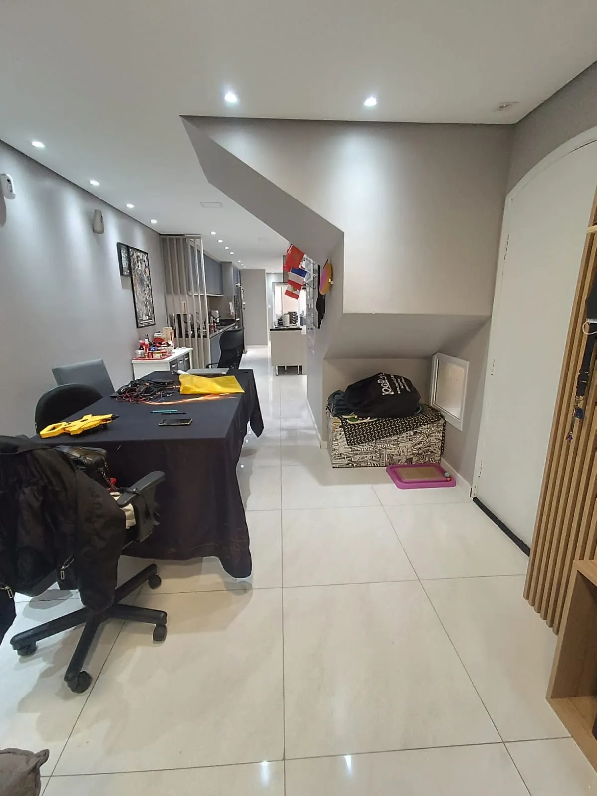 Corredor com mesa de trabalho improvisada e nicho de arrumação embaixo da escada, antes da reforma