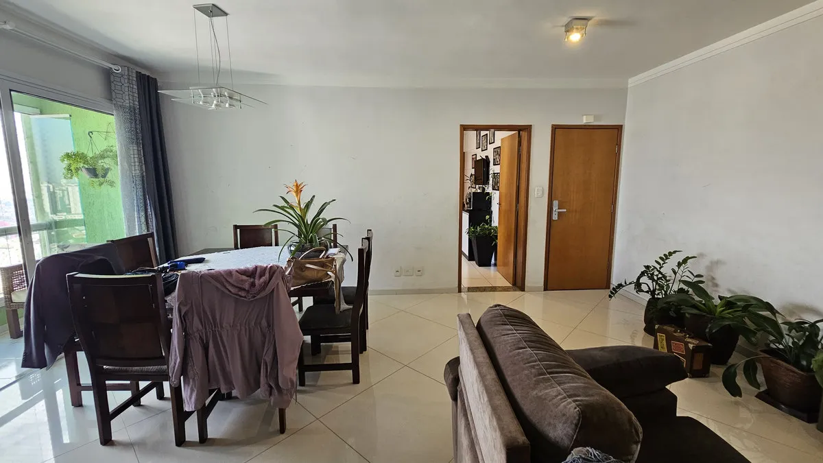 Mesa de jantar de madeira escura, portas de madeira envernizada e varanda envidraçada ao fundo, antes da reforma