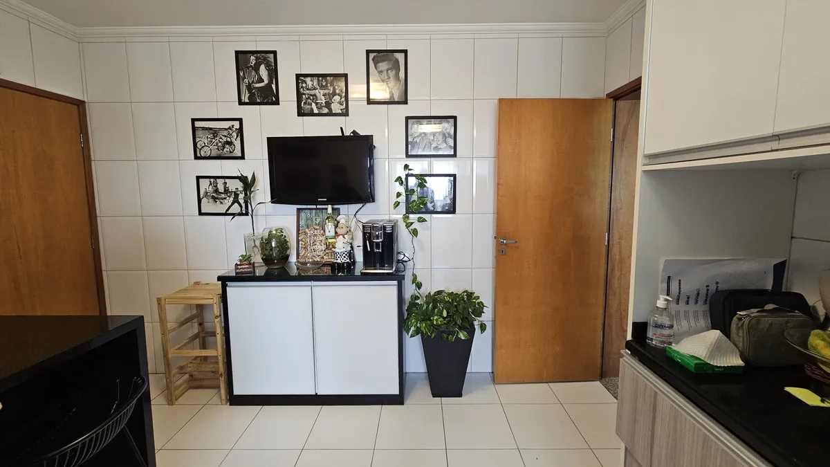 Cozinha antiga com azulejo branco, porta de madeira, galeria de quadros preto e branco e buffet branco, antes da reforma