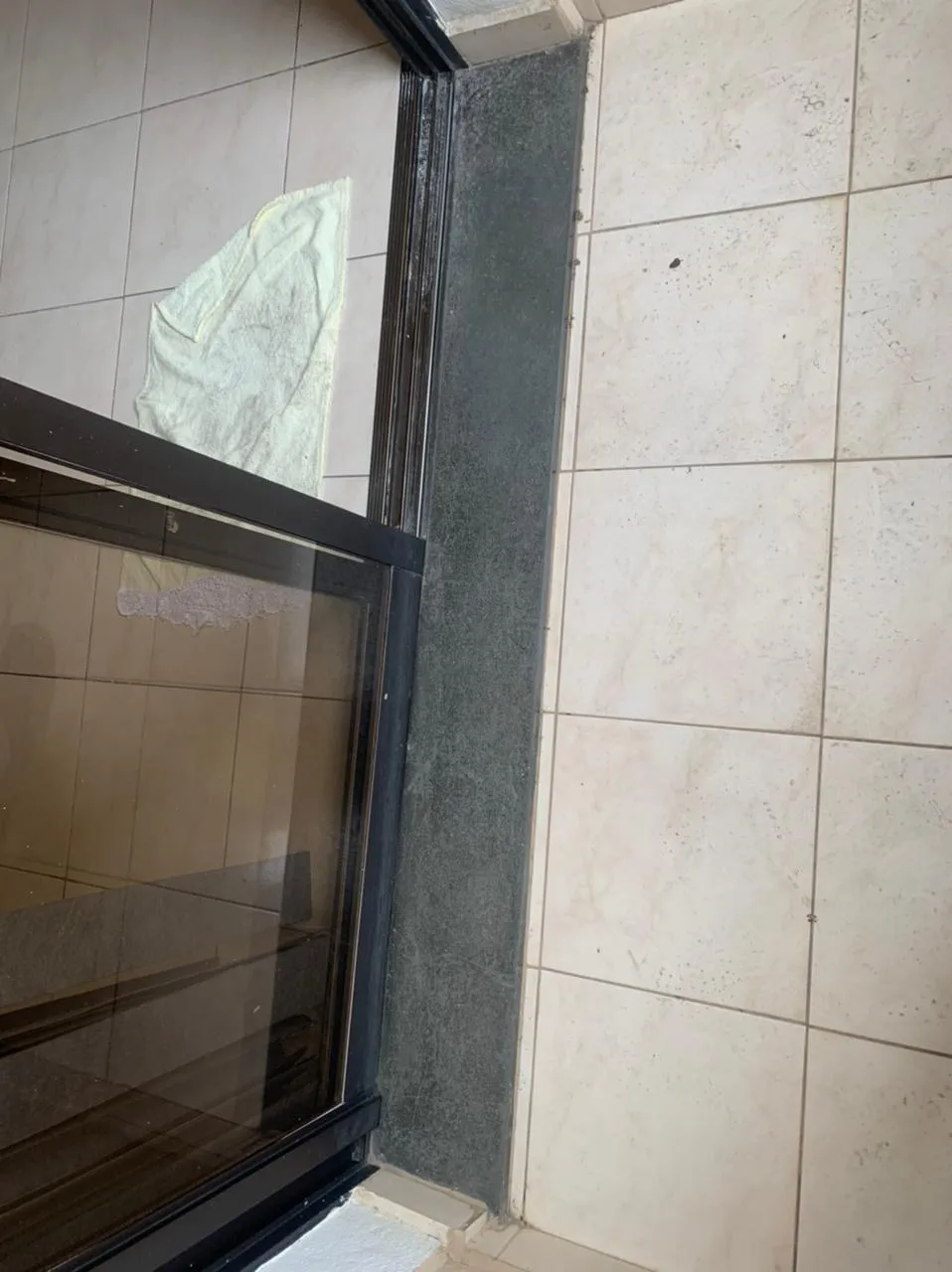 Detalhe da soleira de granito da porta de correr e do piso de cerâmica encardido, antes da reforma