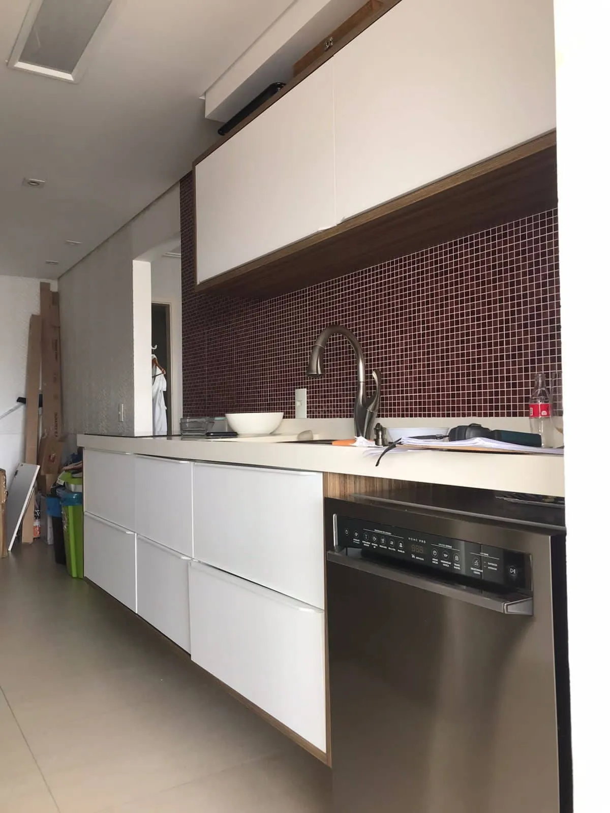 Cozinha com pastilhas vinho, marcenaria branca e lava-louças inox, antes da reforma