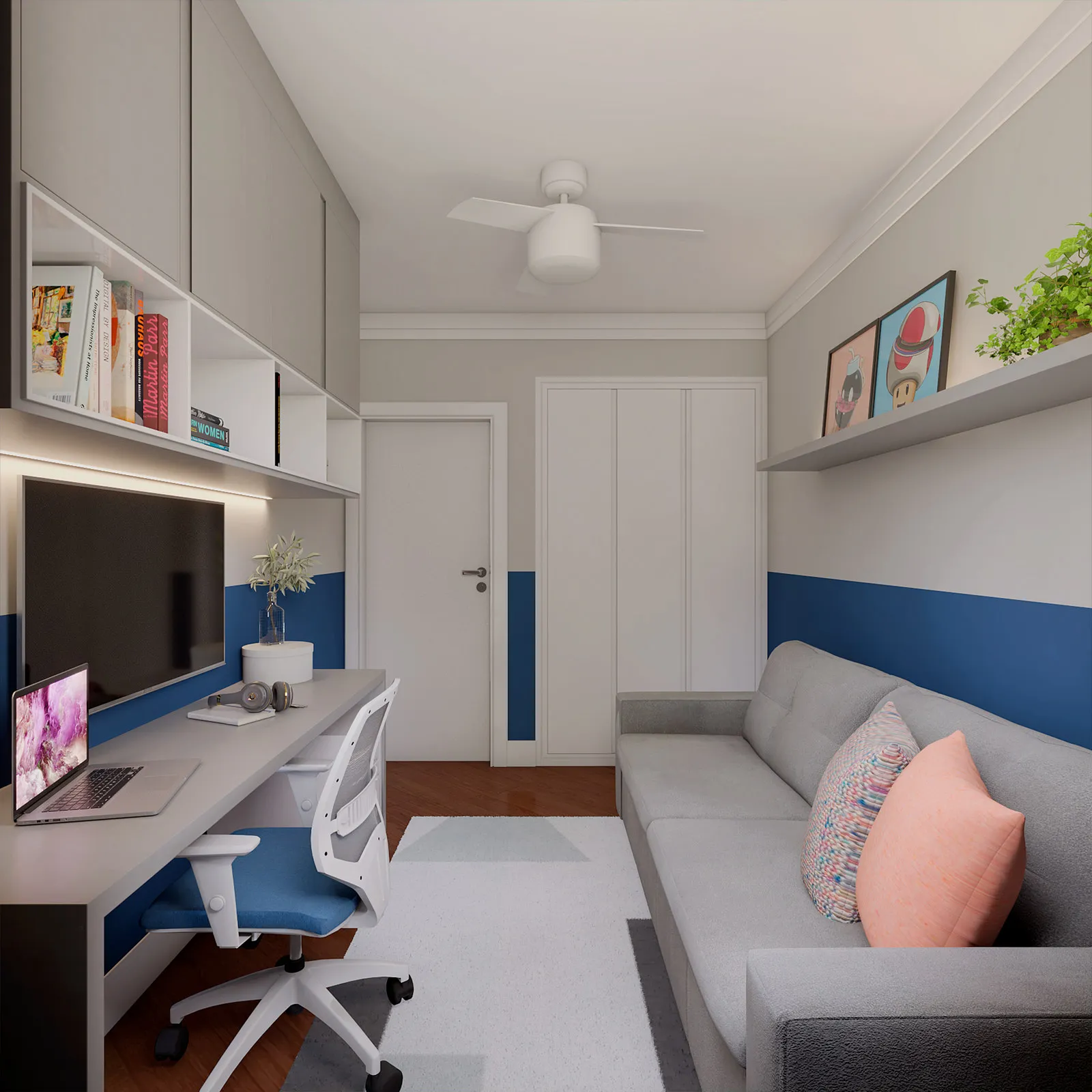Quarto multiuso com bancada de estudo e notebook, TV na parede, sofá cinza com almofadas, guarda-roupa branco e prateleira com quadros pop