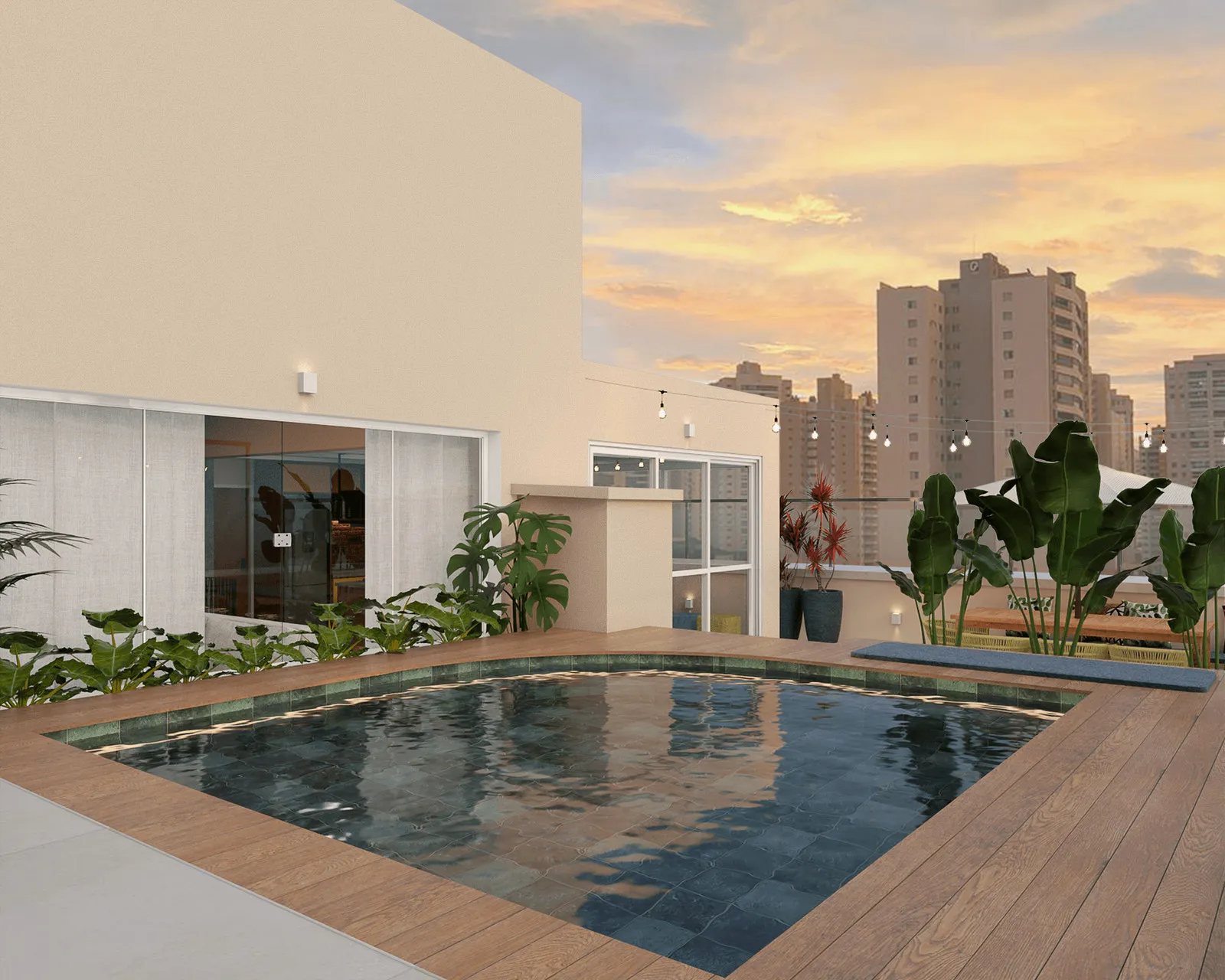 Piscina na cobertura revestida de pastilha verde, deck de madeira, plantas tropicais e vista da cidade ao entardecer