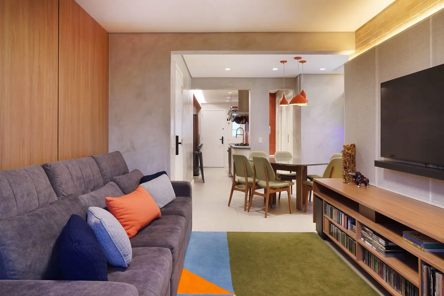 Sala de estar integrada com jantar ao fundo e pendentes laranja, apartamento na Pompéia